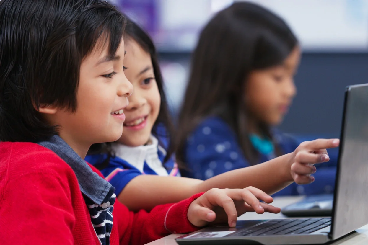 Two children looking at a laptop