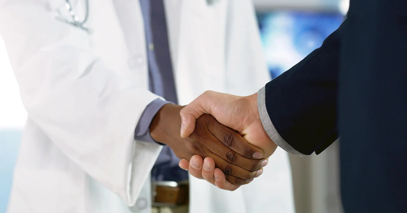 doctor and person in suit shaking hands